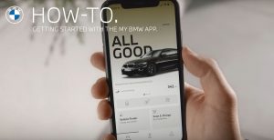 person holding phone displaying My BMW Mobile App